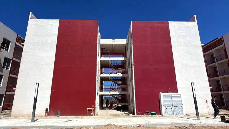 Dos edificios con grandes muros en color vino a cada lado del cubo de escaleras